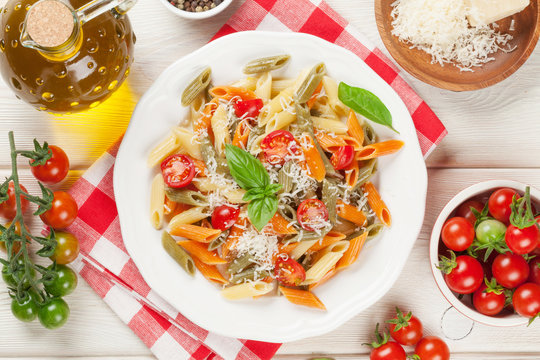 Colorful penne pasta with tomatoes and basil