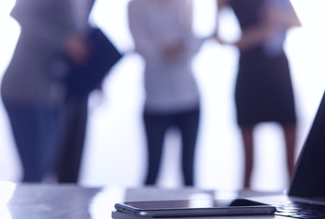 Laptop  computer on  desk ,  businesspeople standing in the