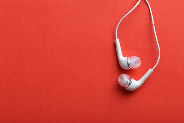 White headphones on a red paper background