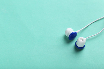 White headphones on a mint paper background