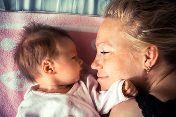 Newborn with mother looking at each other symbolizing love and child care