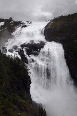 Fototapeta na wymiar Waterfall in Husedalen valley in Hardangervidda national park, Norway