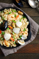 Paella with seafood and spices in pan