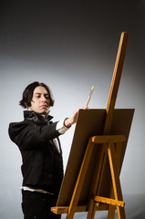 Funny artist in dark studio