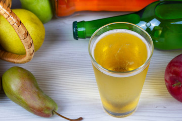 Glass and bottles of cider. Apples and pears