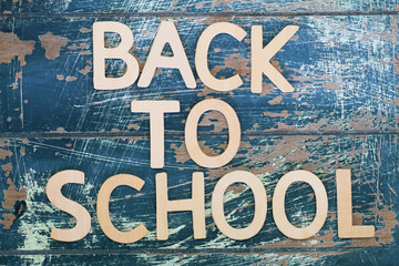 Back to school written on rustic wooden surface
