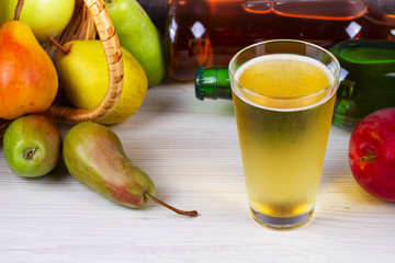 Glass and bottles of cider. Apples and pears