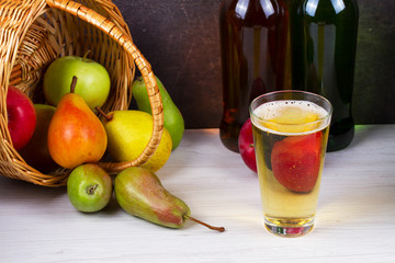 Glass and bottles of cider. Apples and pears