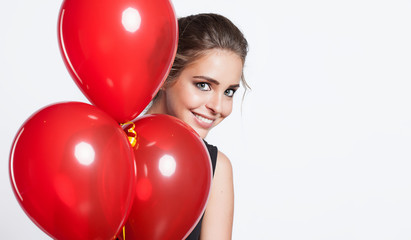 Smiling girl hiding behind balloons