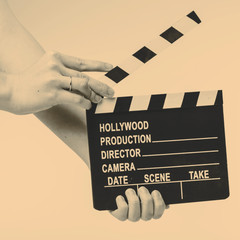Movie flapper in woman´s hands on white background