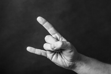 Heavy metal gesture. Hardcore music hand sign. Fingers isolated on black.  - obrazy, fototapety, plakaty