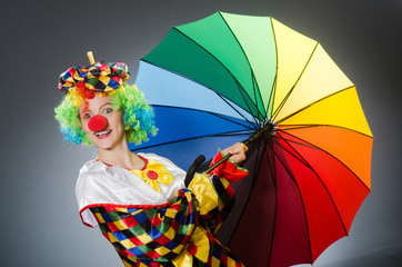 Clown with umbrella in funny concept