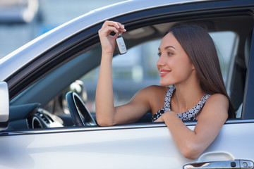 Beautiful young woman has bought a new vehicle