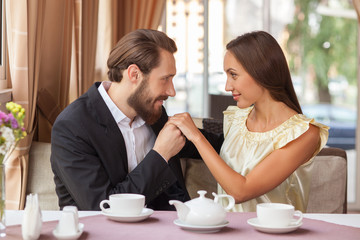 Beautiful young loving couple is dating in cafe