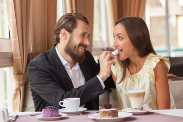 Beautiful loving couple is eating in restaurant