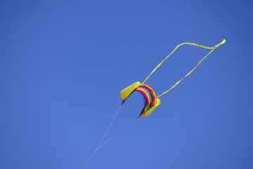 Colorful kite flying in the wind against the blue sky
