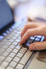 Close up of male hand typing keying on laptop computer keyboard