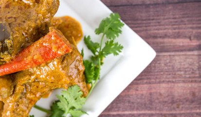 Lamb curry on a white plate over wooden background
