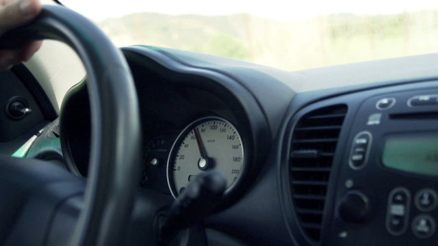 Car speedometer, driver behind the wheel, slow motion shot at 240fps
