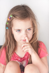 a portrait of a little girl picking her nose