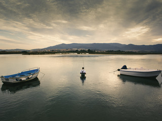 Fototapeta na wymiar Artisan fisherman between fishing boats in the marshes of the river Palmones. Cadiz.