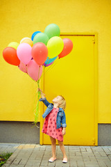 Fototapeta na wymiar happy little girl outdoors with balloons