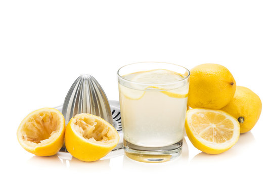 Freshly squeezed organic lemon juice with glass and squeezer.