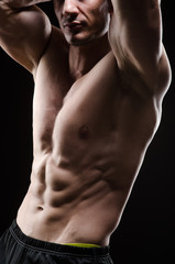 Fototapeta premium Muscular man posing in dark studio