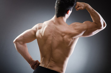 Muscular man posing in dark studio