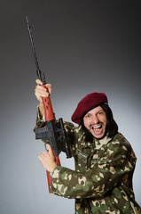 Soldier with handgun against gray