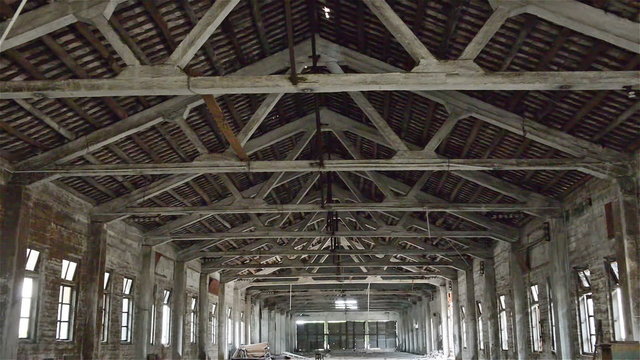 roof of an empty industrial loft in an architectural background with bare cement walls floors and pillars zooming in