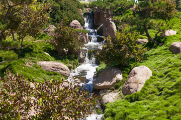 Small waterfall in the park at summer time. 