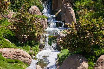 Fototapeta na wymiar Small waterfall in the park at summer time. 