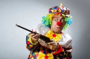 Clown with rifle isolated on white