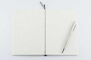 Opened notepad with pen on white background.