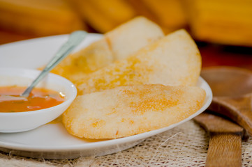 Three empanadas nicely arranged on white platter next to small