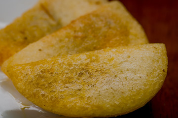 Closeup three perfect empanadas on white plate with wooden