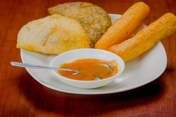 Mixed white plate of typical latin food including empanadas and
