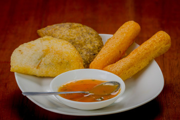 Mixed white plate of typical latin food including empanadas and