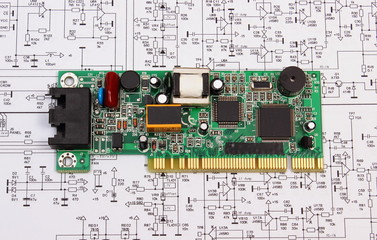 Printed circuit board lying on diagram of electronics, technology