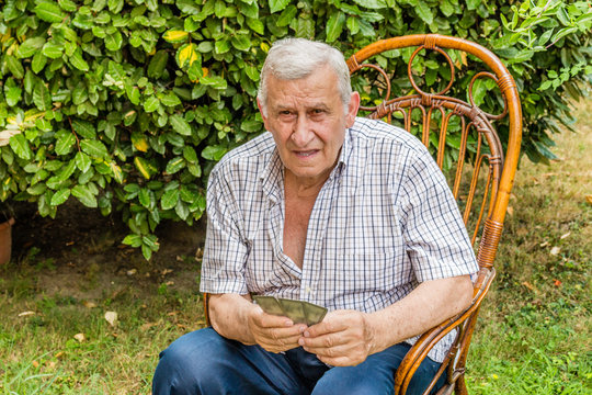 octogenarian elder play cards in the garden