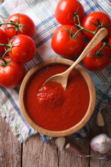 tomato sauce with garlic and basil in a bowl closeup. vertical top view
