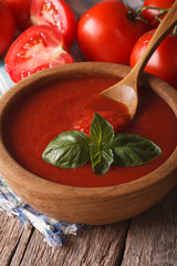 red tomato sauce with basil in a wooden bowl closeup. vertical
