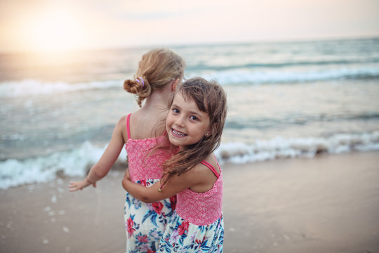 Two happy young girls playing on the beach