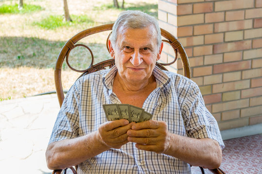 octogenarian elder play cards on the patio