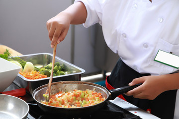 Chef in restaurant kitchen cooking