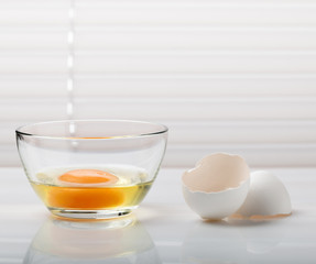 Broken egg in glass bowl