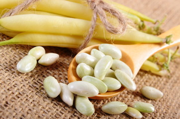 Seeds and stack of yellow beans on jute canvas, healthy food