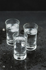 A glass of vodka on the black table
