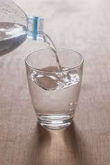 Water splashing out of a bottle on wooden